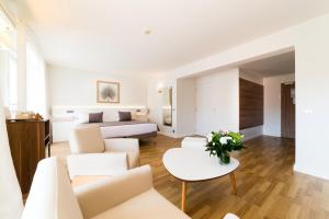 a hotel room with a bed and a living room at Hôtel Hélios in Juan-les-Pins