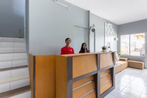 a man and woman standing behind a counter in a room at Super OYO Collection O 3130 D'Valley View in Lembang