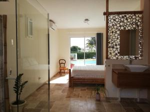 Schlafzimmer mit einem Bett, einem Waschbecken und einem Spiegel in der Unterkunft Villa BELLE VUE, CHAMBRE BAMBOUS in Ravine des Cabris