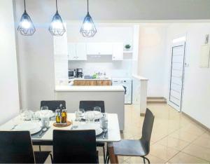 een eetkamer met een tafel en stoelen en een keuken bij Secondhome102 in Paphos City