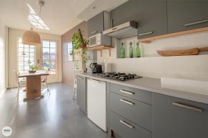 cocina con fogones y mesa. en Villa Caroline - Chambres d'Hôtes en Albi