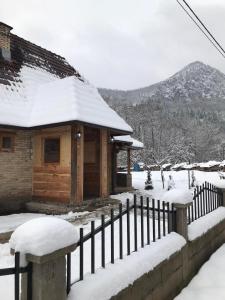eine Holzhütte mit Schnee auf dem Dach in der Unterkunft Planinski biser Mokra Gora in Mokra Gora
