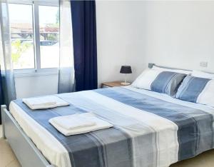 een slaapkamer met een groot bed en handdoeken bij Secondhome102 in Paphos City