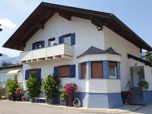 ロイテにあるAnita's Ferienwohnung nahe Neuschwansteinの青い窓とバルコニーが備わる白い家