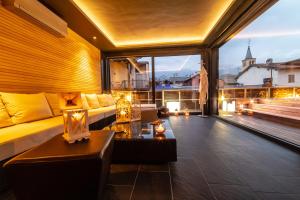 a living room with a couch and a large window at HB Aosta Hotel & Balcony SPA in Aosta