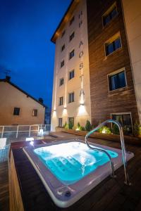 a large swimming pool in front of a large building at HB Aosta Hotel & Balcony SPA in Aosta