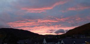 a sunset over a city with houses and mountains at Bannockburn Inn in Helmsdale