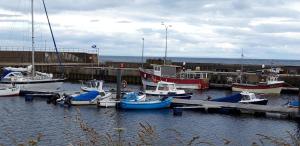 a group of boats docked at a dock in the water at Bannockburn Inn in Helmsdale