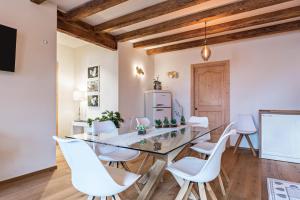 comedor con mesa de cristal y sillas blancas en Wellness Lodge Riccardo en Santa Giuliana