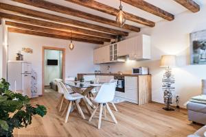 a kitchen and living room with a table and chairs at Wellness Lodge Riccardo in Santa Giuliana