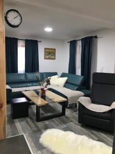 uma sala de estar com um sofá azul e uma mesa de centro em Planinski biser Mokra Gora em Mokra Gora