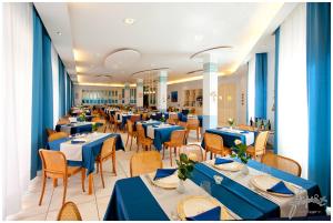 a dining room with blue tables and chairs at Hotel Nuovo Al Mare in Alassio