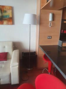 a room with a desk and a lamp and a chair at Departamento 2 ambientes mas terraza amoblada, Providencia in Santiago +18 photos