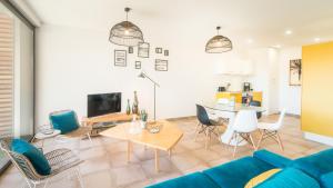 Una sala de estar con un sofá azul y una mesa. en Open Sun avec Jacuzzi Privatif et parking privé, en Sarlat-la-Canéda 7 fotos más