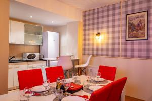 comedor con mesa y sillas rojas en Clabucet Nest DeLuxe Apartment en Predeal