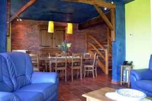 a living room with a blue couch and a table at Gîtes Ferme de la Barrière in Chimay