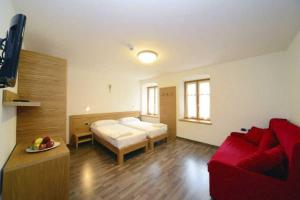 een woonkamer met een bed en een rode bank bij Dimora di frate Sole in Terzolas