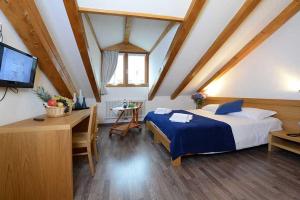 een slaapkamer met een bed, een bureau en een televisie bij Dimora di frate Sole in Terzolas