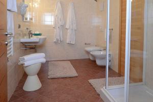 een badkamer met 2 toiletten, een wastafel en een douche bij Dimora di frate Sole in Terzolas