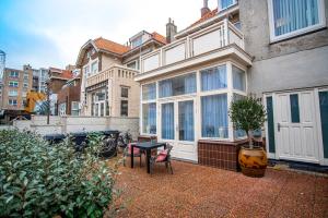 a patio with a table and chairs in front of a house at Beach Studio Boom in Zandvoort