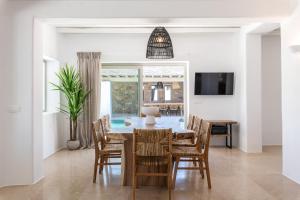 a dining room with a table and chairs at Mykonos AG Villas in Ftelia