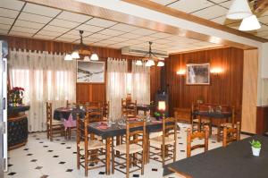 a dining room with tables and wooden walls and chairs at Hotel Suiza in Bronchales