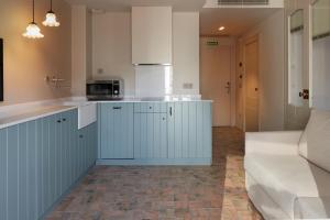 a kitchen with blue and white cabinets and a couch at Pamplonapartments Pozo Blanco in Pamplona