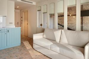 a living room with a white couch and a kitchen at Pamplonapartments Pozo Blanco in Pamplona