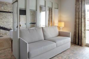 - un canapé blanc dans le salon doté de fenêtres dans l'établissement Pamplonapartments Pozo Blanco, à Pampelune