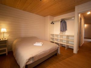 Lacanau Moutchic Inn في لاكانو: غرفة نوم بسرير في غرفة ارفف