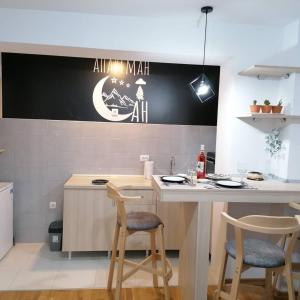 a kitchen with a table and stools in a room at Apartman San in Vrnjačka Banja