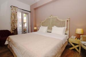 sypialnia z dużym białym łóżkiem i oknem w obiekcie Amaryllis w mieście Nafpaktos