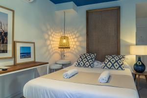 a bedroom with a large white bed with two pillows at YOU & CO. Saler Beach Boutique in Valencia