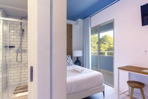 a bedroom with a bed and a bathroom with a shower at YOU & CO. Saler Beach Boutique in Valencia