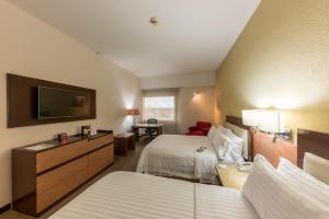 um quarto de hotel com duas camas e uma televisão de ecrã plano em Holiday Inn Guadalajara Select, an IHG Hotel em Guadalajara