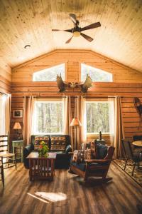 a living room with a couch and a ceiling fan at Denali Wild Stay - Moose Cabin, Free Wifi, 2 private bedrooms, sleep 6 in Healy