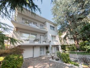 un edificio de apartamentos blanco con balcón y árboles en Sweet Studio IN GIARDINO, en Padua
