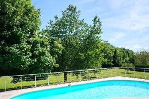 uma piscina com cerca e árvores em Les Feuillantines Perigord Noir em Saint-Cyprien