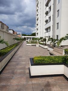 un balcone di un edificio con panchine e piante di Lindo Apartamento Completo, en una muy buena zona a Cúcuta