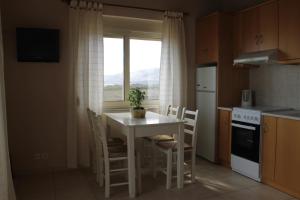 a kitchen with a table and chairs and a window at Argilos Apartments in Frangokastello