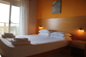 1 dormitorio con 1 cama con toallas en Argilos Apartments, en Frangokastello