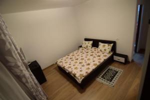a bedroom with a bed with a bedspread and pillows at Agropensiune CASA SONIA in Băcia