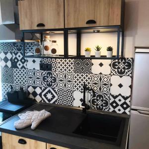 een keuken met zwarte en witte tegels op de muur bij Los vagones 3 in Vatopedi