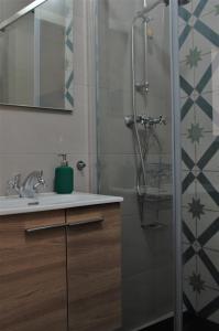 y baño con ducha y lavamanos. en Città Cospicua suites, en Cospicua