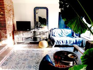 a living room with a couch and a mirror at la fermette des grains dorés in Lafrançaise