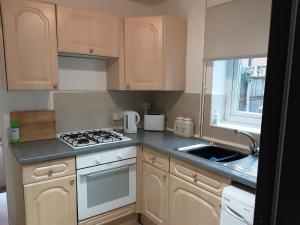 a small kitchen with a stove and a sink at Village 3-Bed House Netflix in Chester in Chester