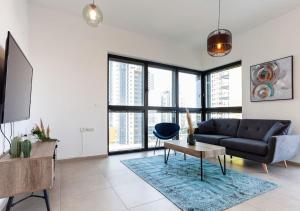 a living room with a couch and a table at Oַ&O Group- Luxury APT Tower Spectacular Sea View in Bat Yam
