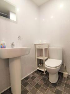 a bathroom with a white toilet and a sink at Anglesey House in Llandudno