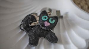 ein kleines schwarzes Katzenspielzeug mit grünen Augen in der Unterkunft Domki u Kota i Psa in Jastarnia