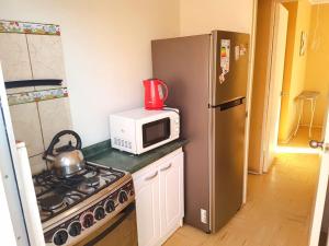 a kitchen with a microwave and a stove and a refrigerator at Casa la serena condominio D. Gabriela in La Serena +14 photos
